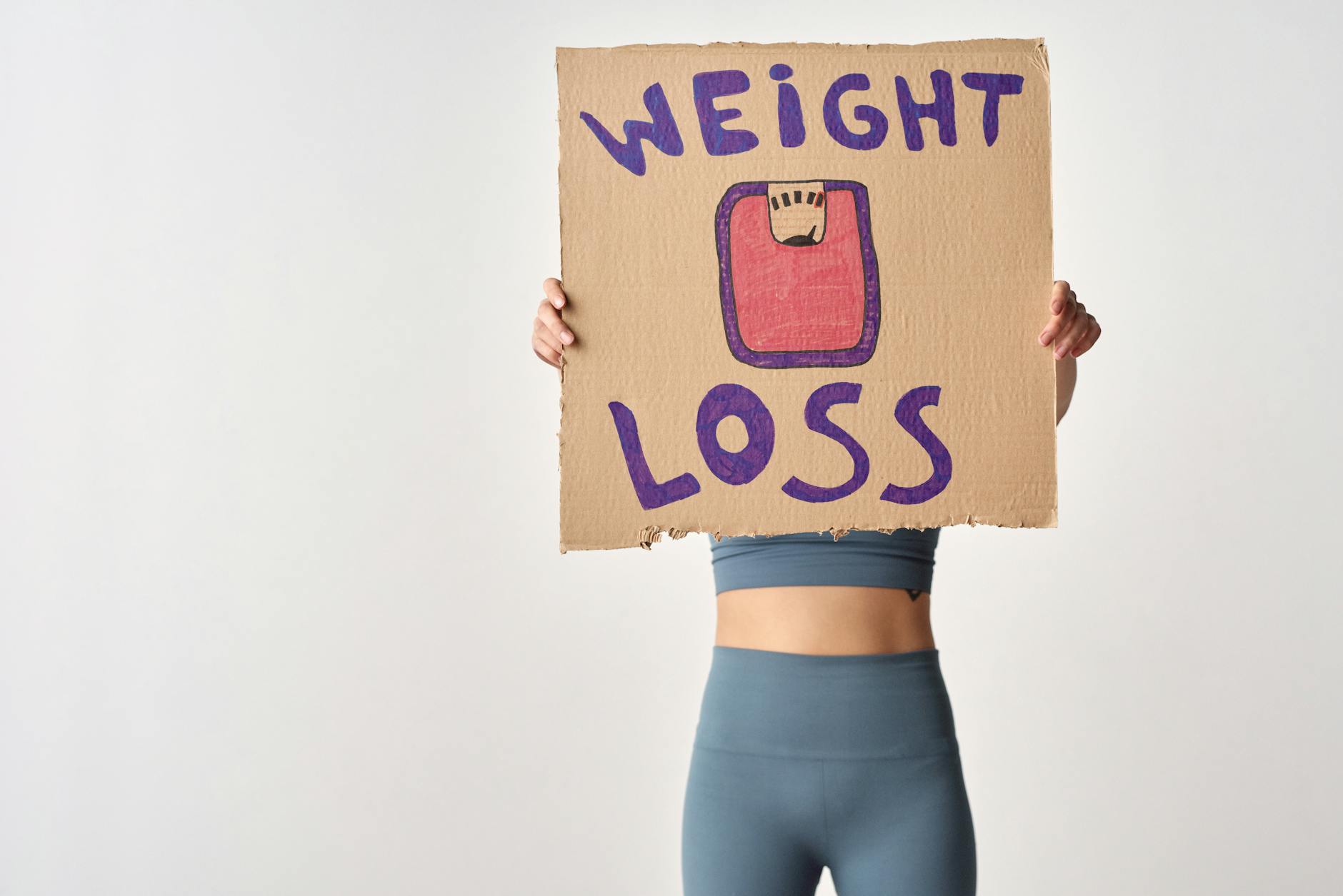 Osoba trzymająca kartkę z napisem weight loss jako cel odchudzania