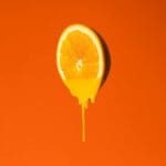 Soczysta kropla soku spadająca z plasterka pomarańczy