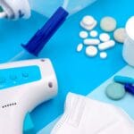 Kroplówki witaminowe a redukcja masy ciała: wsparcie metabolizmu czy marketingowy chwyt Leki, maseczka i termometr ułożone na niebieskim tle